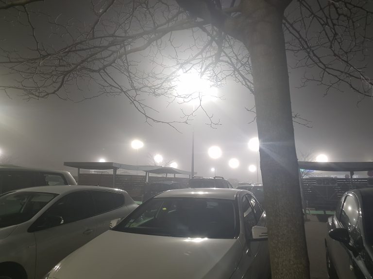 Photo prise dans un parking, de nuit, dans un épais brouillard.